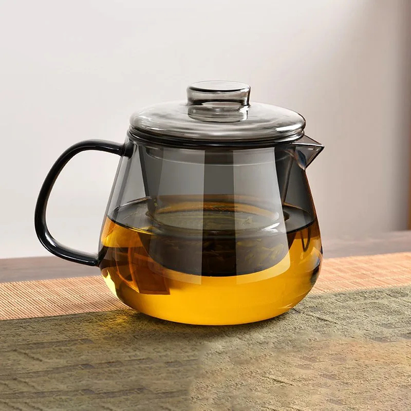 Dark borosilicate glass teapot with lid brewing loose leaf tea, modern heat-resistant stovetop safe tea maker