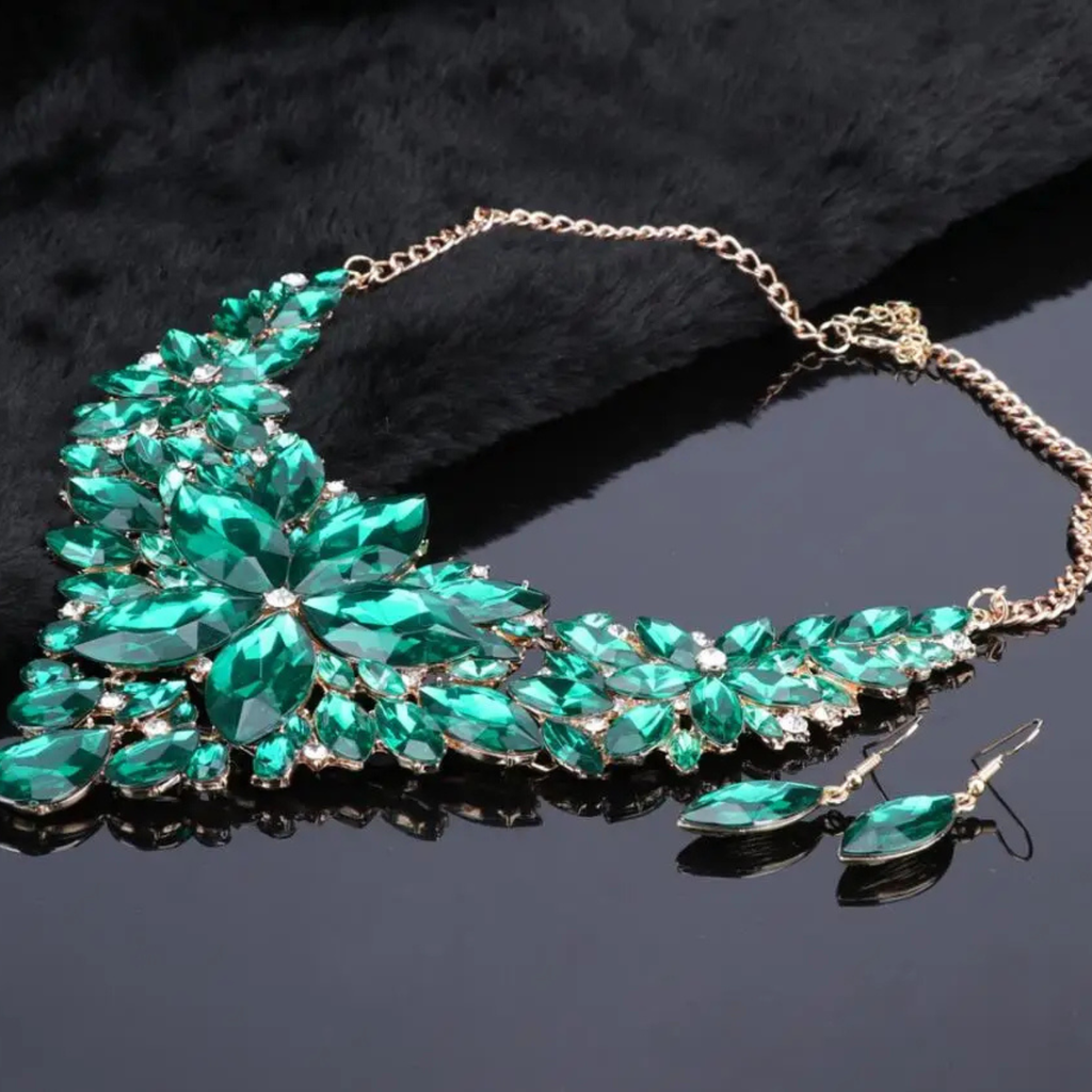 Elegant green crystal bridal jewelry set with floral statement necklace and matching earrings on gold chain, perfect for weddings and formal occasions