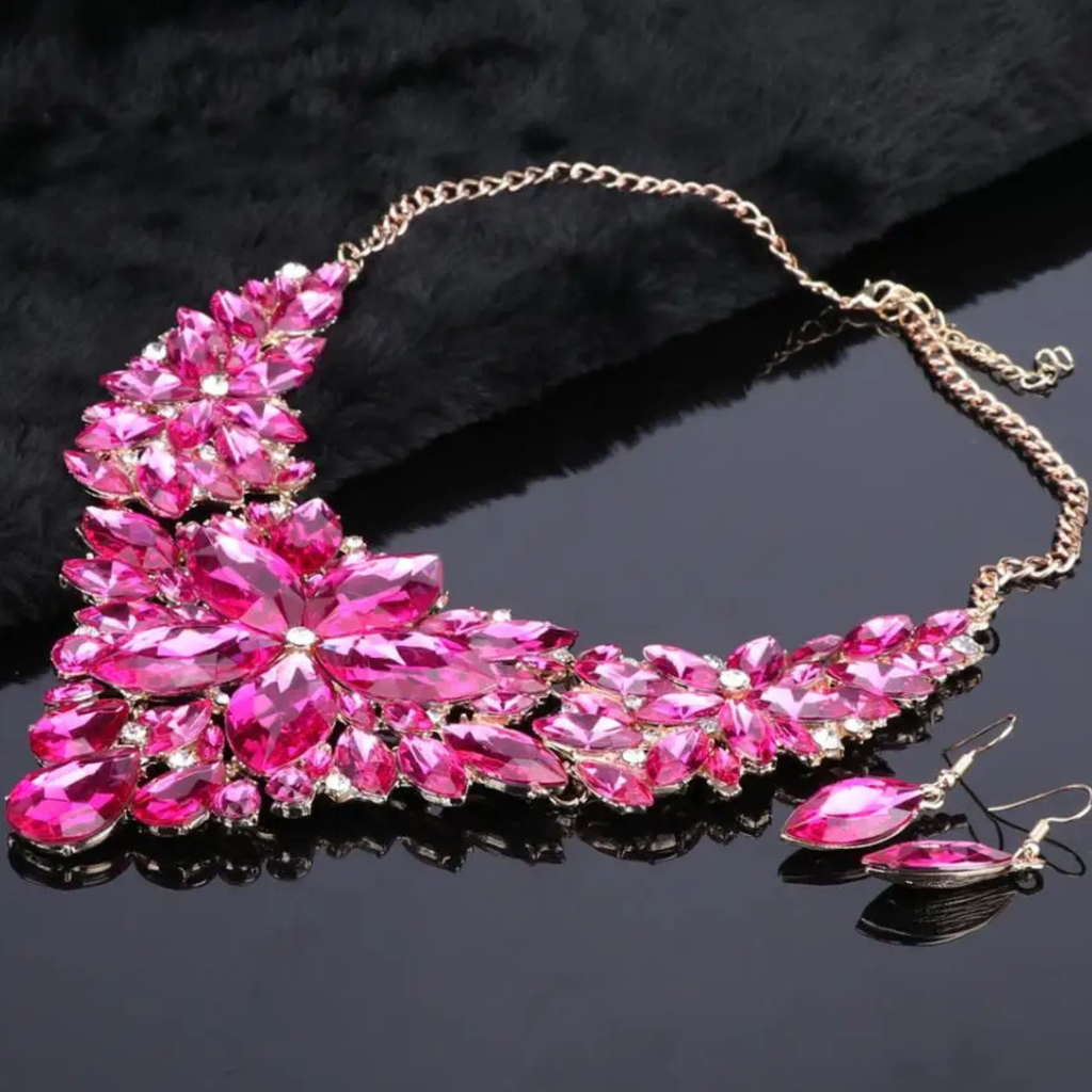 Elegant pink crystal bridal jewelry set with floral statement necklace and matching earrings on gold chain, perfect for weddings, parties, and formal occasions