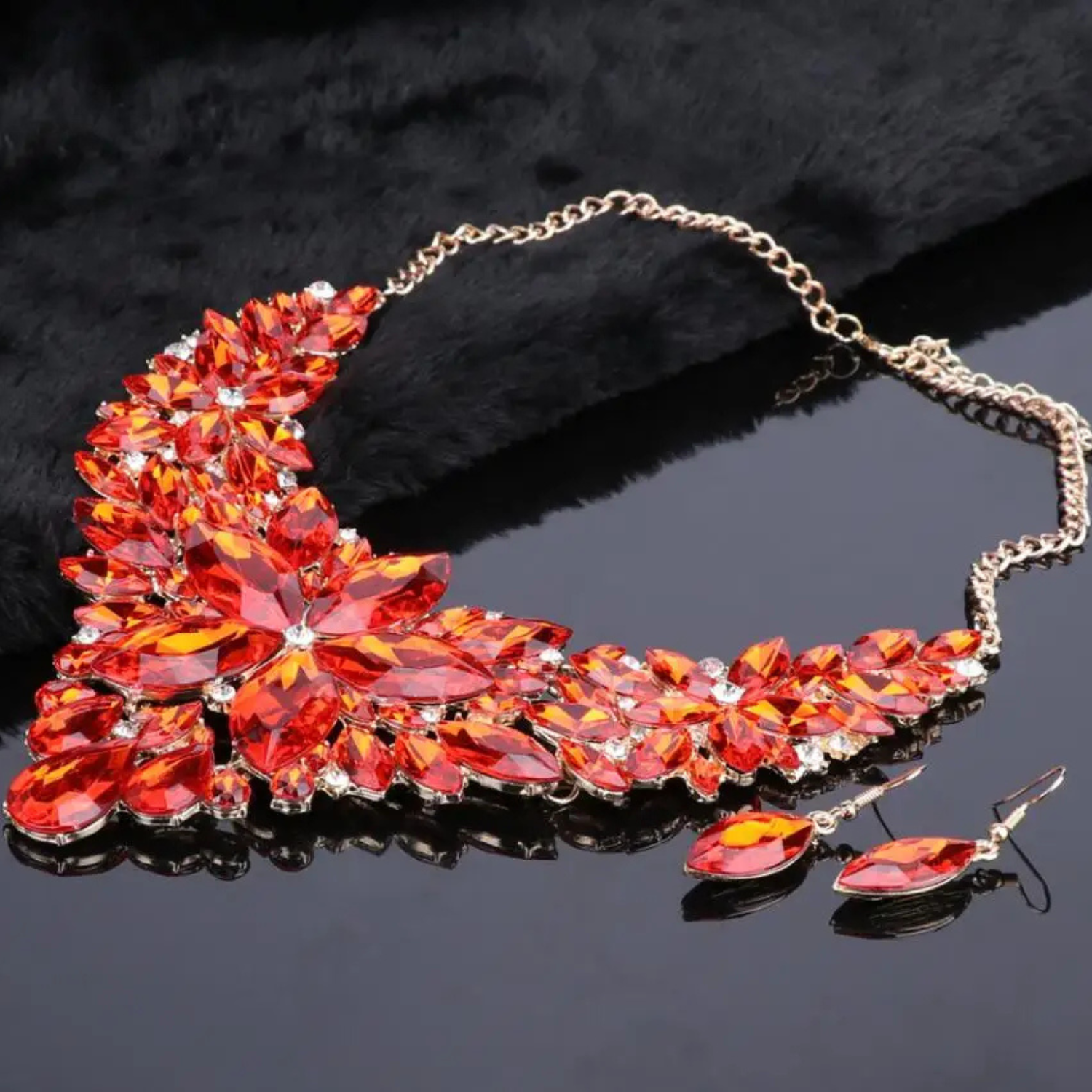 Elegant red crystal bridal jewelry set with floral statement necklace and matching earrings on gold chain, perfect for weddings, parties, and formal occasions